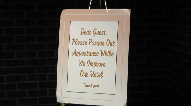Sign reading 'Dear Guest, Please Pardon Our Appearance While We Improve Our Hotel"