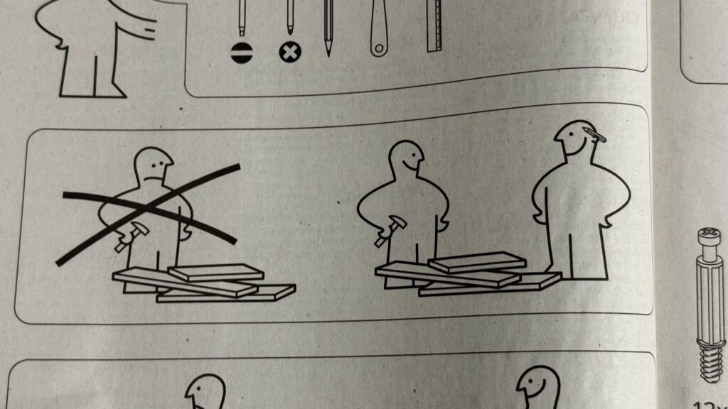Furniture assembly instructions.  On the left, a crossed out image of a lone figure, frowning, standing next to a disordered pile of parts. On the right, two smiling figures,  standing next to the same pile of parts.